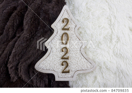 Christmas and 2022 New Year concept. Christmas tree decoration is made from wool on the brown and white fur background. 84709835