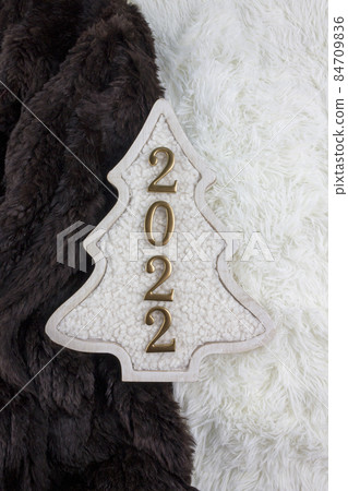 Christmas and 2022 New Year concept. Christmas tree decoration is made from wool on the brown and white fur background. 84709836