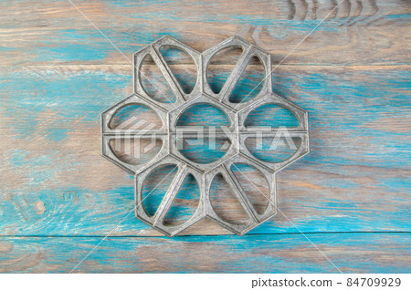 Old aluminum dumplings mold on blue wooden background. Old aluminum dumplings mold on blue wooden background. 84709929