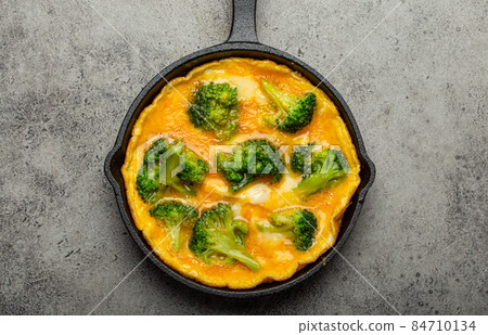 Healthy omelette with broccoli in cast iron pan top view 84710134