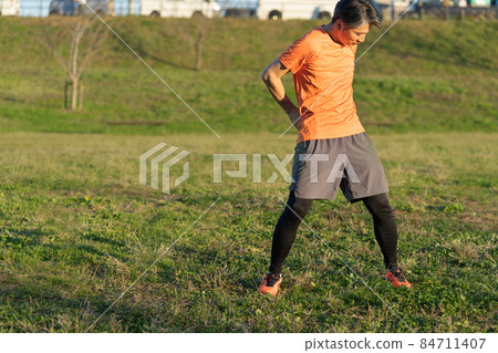Middle-aged man stretching in the evening 84711407