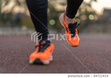 Up the feet of a man jogging in the setting sun Up the feet of a man jogging in the setting sun 84712414
