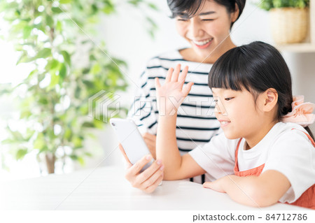 Parents and children (mother and child) enjoying together on their smartphones 84712786