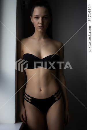 Alluring woman in underwear leaning on wall near window 84714344
