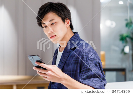 Businessman using a smartphone in the office Photo cooperation: WEEK Shibadaimon (Sun Frontier Fudousan) Businessman using a smartphone in the office Photo cooperation: WEEK Shibadaimon (Sun Frontier Fudousan) 84714509