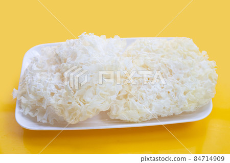Tremella Mushroom in white plate on yellow background. 84714909