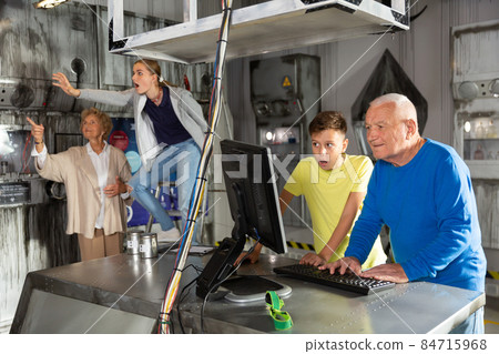 Grandparents and grandkids solving conundrums in escape room 84715968