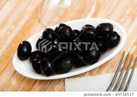 Pickled black olives in white bowl 84716537