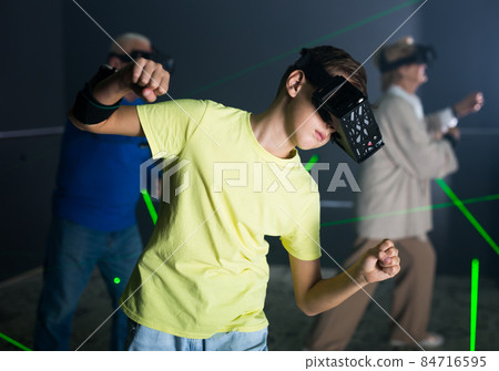 Boy in VR headset playing games with his family Boy in VR headset playing games with his family 84716595