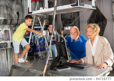 Family is using PC in time having fun together in lost labroom 84716777