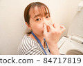 一個女人在擦馬桶，捏著鼻子 84717819