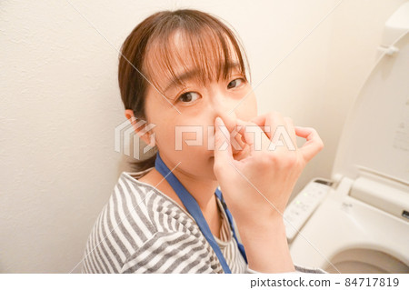 一個女人在擦馬桶，捏著鼻子 84717819
