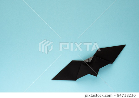 Black origami bats on a light blue background 84718230