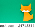 Orange origami cat on green background 84718234