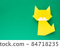 Yellow origami cat on green background 84718235