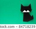 Black origami cat on green background 84718239