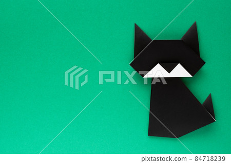 Black origami cat on green background 84718239