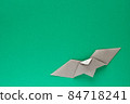 Gray origami bat on green background 84718241