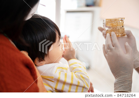 兒科牙醫使用模型向母親解釋孩子的牙齒的圖片 兒科牙醫使用模型向母親解釋孩子的牙齒的圖片 84718264