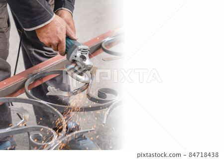 Metal grinding with angle grinder. Sparks fly on the sides. Male hand and instrument close-up. Banner, copy-space. Metal grinding with angle grinder. Sparks fly on the sides. Male hand and instrument close-up. Banner, copy-space. 84718438