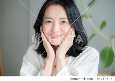 A beautiful Asian (Japanese) woman who smiles because she cares about her skin condition. Looking at the camera in front of her. A beautiful Asian (Japanese) woman who smiles because she cares about her skin condition. Looking at the camera in front of her. 84718507