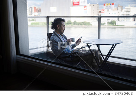 日本男人一邊在陽台上放鬆一邊看著智能手機 9 剪影 日本男人一邊在陽台上放鬆一邊看著智能手機 9 剪影 84720468