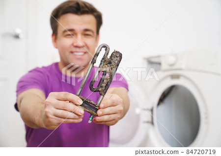 repairman of washing machine holds old tubular electric heater repairman of washing machine holds old tubular electric heater 84720719