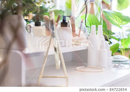 Table mirror on dressing table with make up accessories. Self-Care. White, pastel interior Table mirror on dressing table with make up accessories. Self-Care. White, pastel interior 84722654