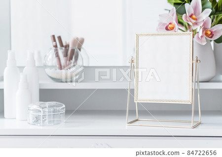 Table mirror on dressing table with make up accessories. Self-Care. White, pastel interior Table mirror on dressing table with make up accessories. Self-Care. White, pastel interior 84722656