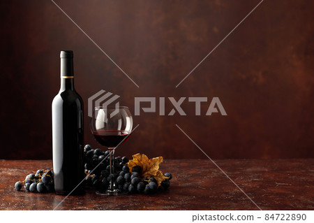 Red wine and grapes on a brown background. Red wine and grapes on a brown background. 84722890