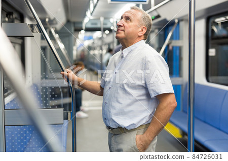 Middle aged man in subway car Middle aged man in subway car 84726031