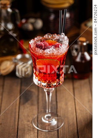Sweet red berry alcohol cocktail in a fancy glass Sweet red berry alcohol cocktail in a fancy glass 84726214