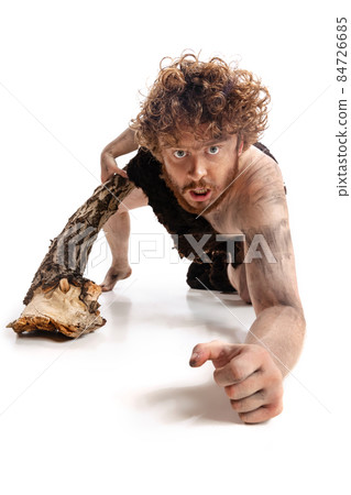 Full-length portrait of artistic man in character of neanderthal posing isolated over white background 84726685