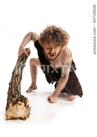 Full-length portrait of man in character of neanderthal climbing with angry expression isolated over white background 84726686