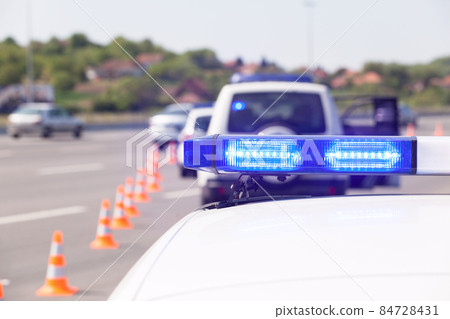 Police car emergency lighting during highway traffic control 84728431