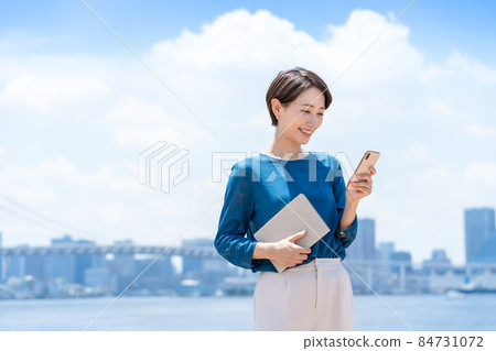 Female business blue sky smartphone 84731072