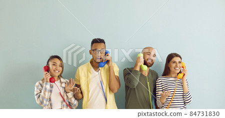 Diverse group of happy people talking on fixed line telephones. Studio portrait of four different young multiracial males and females calling friends and sharing news over phone. Communication concept Diverse group of happy people talking on fixed line telephones. Studio portrait of four different young multiracial males and females calling friends and sharing news over phone. Communication concept 84731830