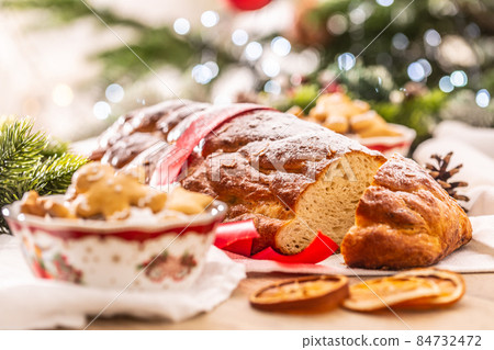 Traditional Czech Christmas cake Vanocka on a festive table in front of a Christmas tree Traditional Czech Christmas cake Vanocka on a festive table in front of a Christmas tree 84732472