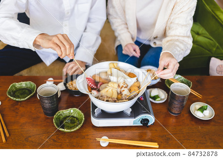 Men and women eating hot pot dishes Men and women eating hot pot dishes 84732878