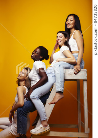 diverse multi nation girls group, teenage friends company cheerful having fun, happy smiling, cute posing on yellow background, lifestyle people concept, african-american, asian and caucasian diverse multi nation girls group, teenage friends company cheerful having fun, happy smiling, cute posing on yellow background, lifestyle people concept, african-american, asian and caucasian 84735820