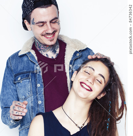 Young couple together. guy with tattoo, girlfriend wearing dreadlocks having fun on white background Young couple together. guy with tattoo, girlfriend wearing dreadlocks having fun on white background 84736342