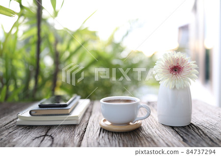 White coffee cup and notebook with gerbera flower White coffee cup and notebook with gerbera flower 84737294