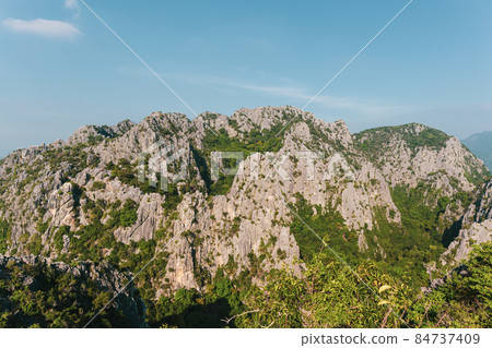 Scenic landscape view of limestone mountain with cliff in tropical forest. Scenic landscape view of limestone mountain with cliff in tropical forest. 84737409