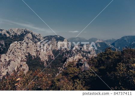 Scenic landscape view of limestone mountain with cliff in tropical forest. Scenic landscape view of limestone mountain with cliff in tropical forest. 84737411