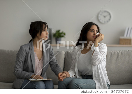 Young psychologist supporting crying middle eastern woman during psychotherapy session. Professional help concept 84737672