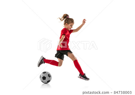 Full-length portrait of little girl, child, training, playing football isolated over white background 84738003