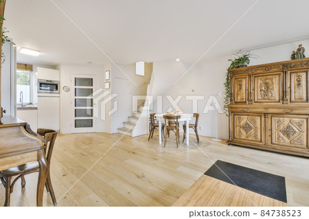 Cozy dining area with round wooden white table and chairs 84738523