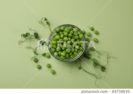 Bowl with pea seeds on green background Bowl with pea seeds on green background 84738630