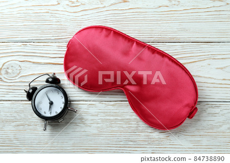 Alarm clock and sleep mask on white wooden background 84738890