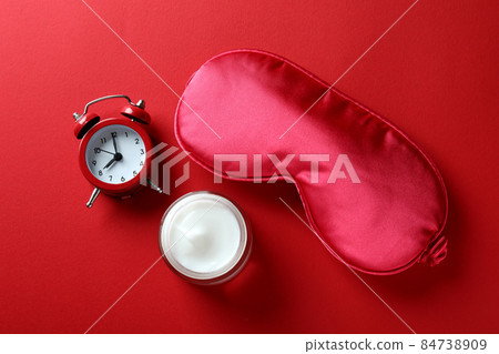 Female sleep routine accessories on red background 84738909